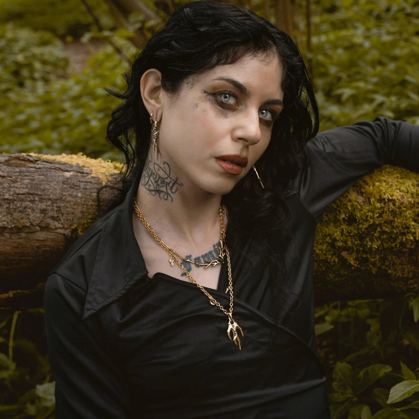 Model wearing Feral Husk Necklace in a forest setting with dark woodland jewelry styling