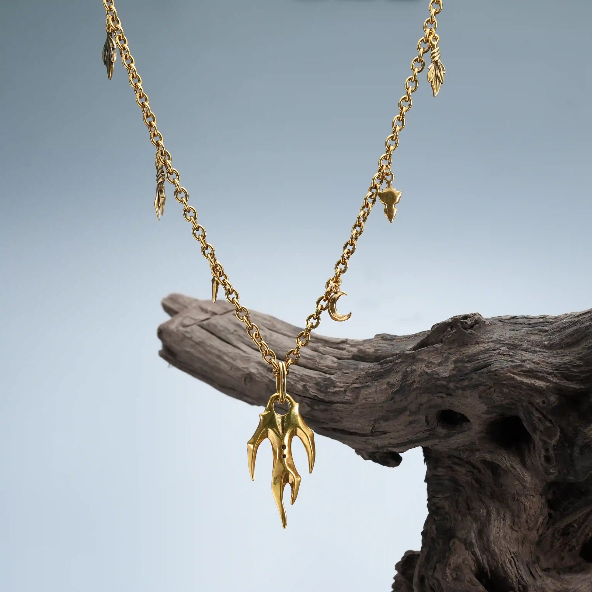 Gold Feral Husk Necklace displayed on weathered wood with woodland relic styling