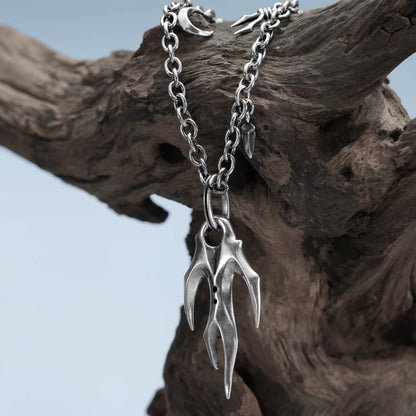 Silver Feral Husk Necklace hanging on weathered wood with dark forest inspired design