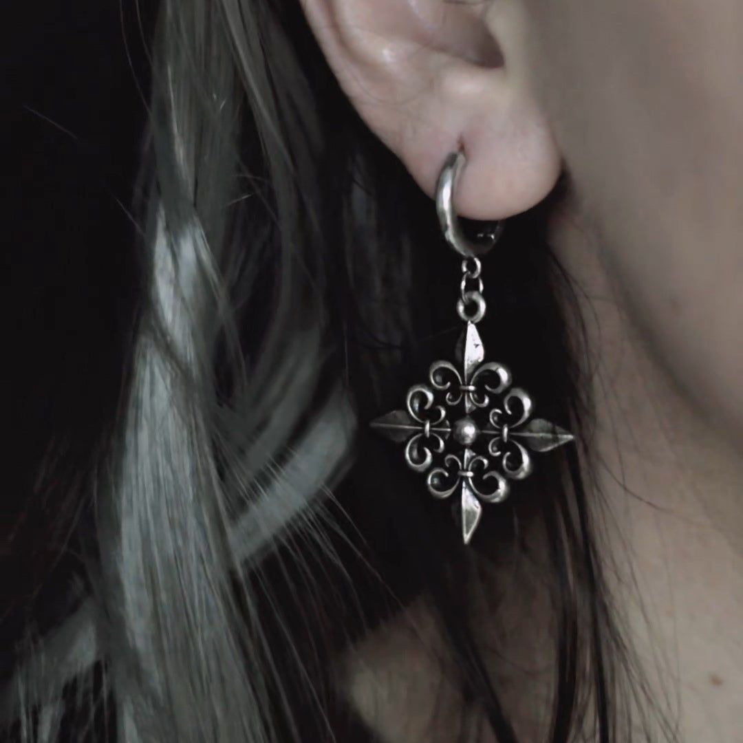 Fleur-de-Lis Elegance Earrings in 925 sterling silver, worn in a tight dark-haired ear close-up, centering the fleur-de-lis p