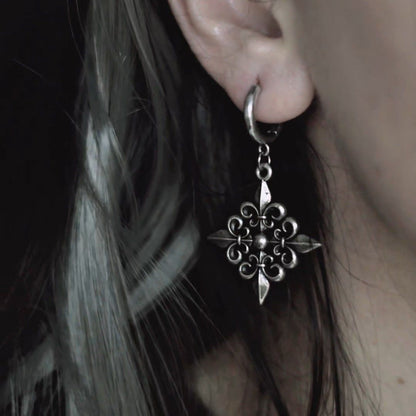 Fleur-de-Lis Elegance Earrings in 925 sterling silver, worn in a tight dark-haired ear close-up, centering the fleur-de-lis p