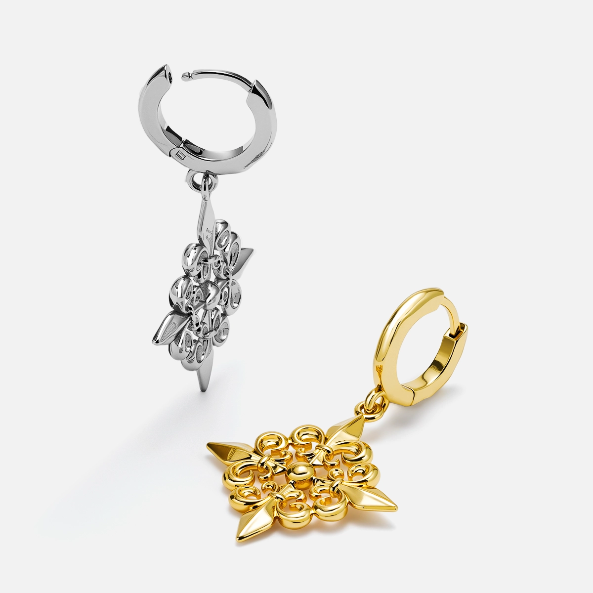 Silver and gold-tone Fleur-de-Lis Elegance hoop earrings arranged upright and flat