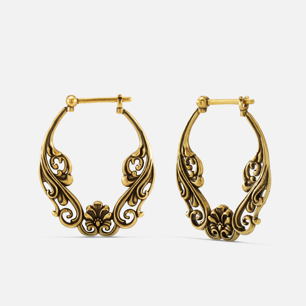Pair of antique gold-tone hoop earrings featuring an ornate floral scroll pattern, front view