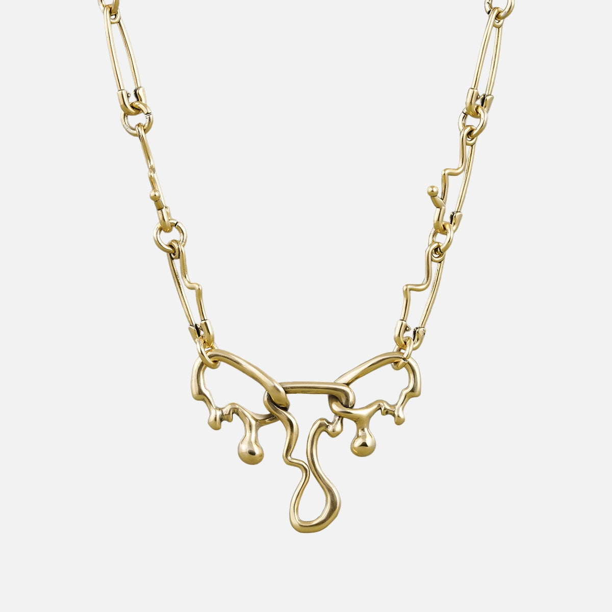 Gold-tone fluid pin necklace with a wavy paperclip chain and dripping abstract pendant, front view
