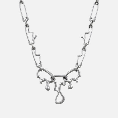 Silver-tone fluid pin necklace with a wavy paperclip chain and dripping abstract pendant, front view