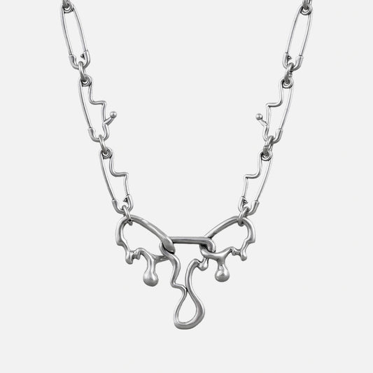 Silver-tone fluid pin necklace with a wavy paperclip chain and dripping abstract pendant, front view