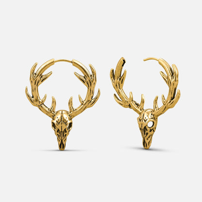 Pair of gold-tone stag skull hoop earrings with antlers displayed side by side against a plain background