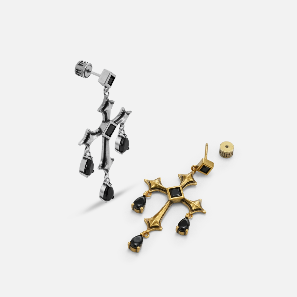 Silver and gold Forsaken Vow Earrings arranged at contrasting angles on white, showing the drop construction.