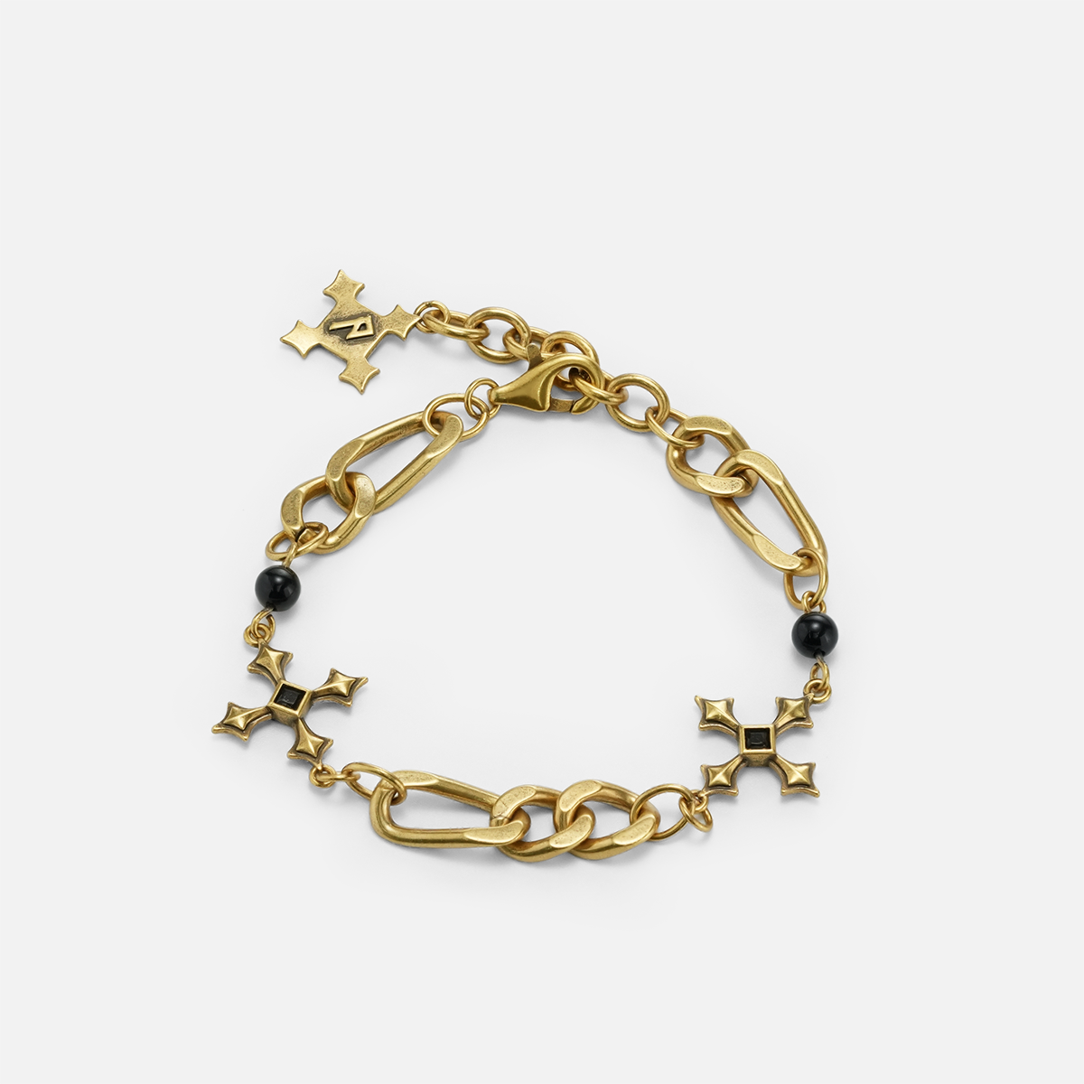 Fractured Creed Bracelet in antiqued 18K gold with fractured cross-inspired metalwork and black obsidian, shown on white.