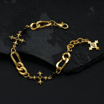 Gold Fractured Creed Bracelet arranged in a loop on black textured fabric.