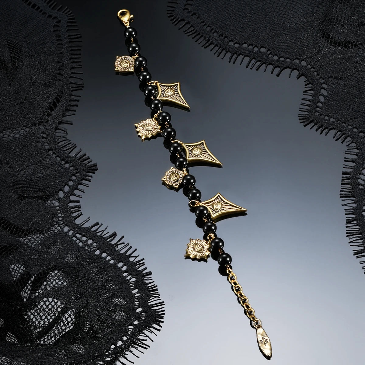 A pair of silver spiral hoop earrings with a scalloped, gear-like inner design, displayed on a glossy black surface.