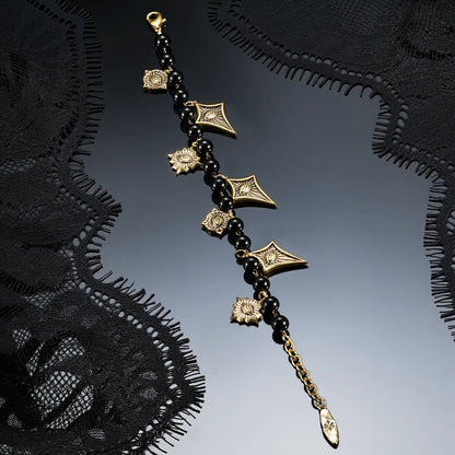 A pair of silver spiral hoop earrings with a scalloped, gear-like inner design, displayed on a glossy black surface.