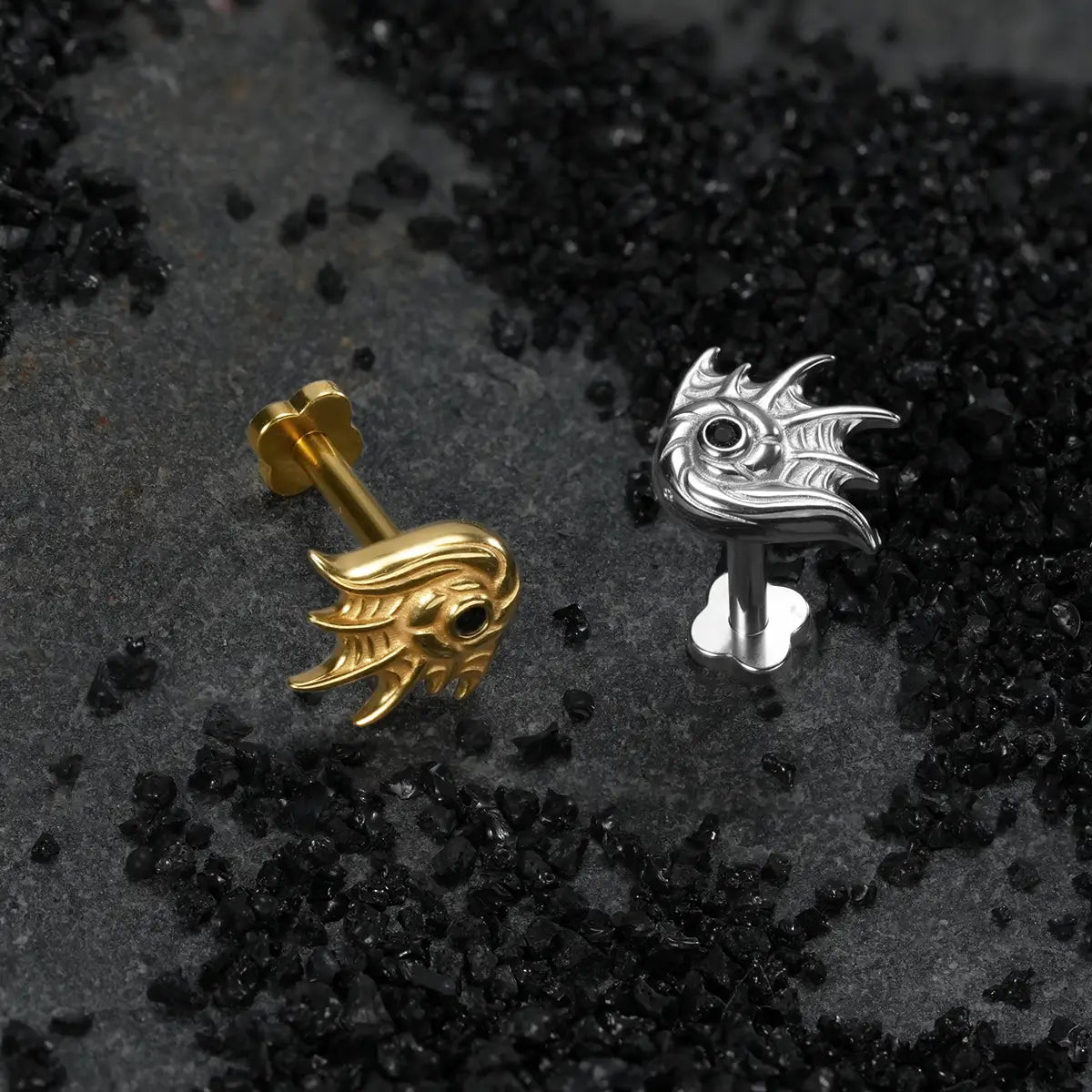 Gold and silver titanium conch flat back studs on dark coastal black sand background