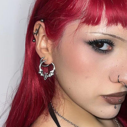 Silver bat hoop earring worn on model with red hair, close-up side profile view