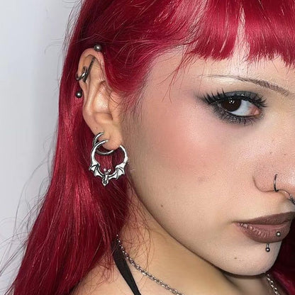 Gothic Bat Earrings in 925 sterling silver, worn in a close portrait with vivid red hair, facial piercings, and dark eye make
