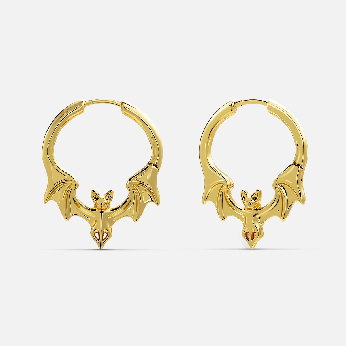 Pair of gold-tone bat hoop earrings with spread wings, front view on white background