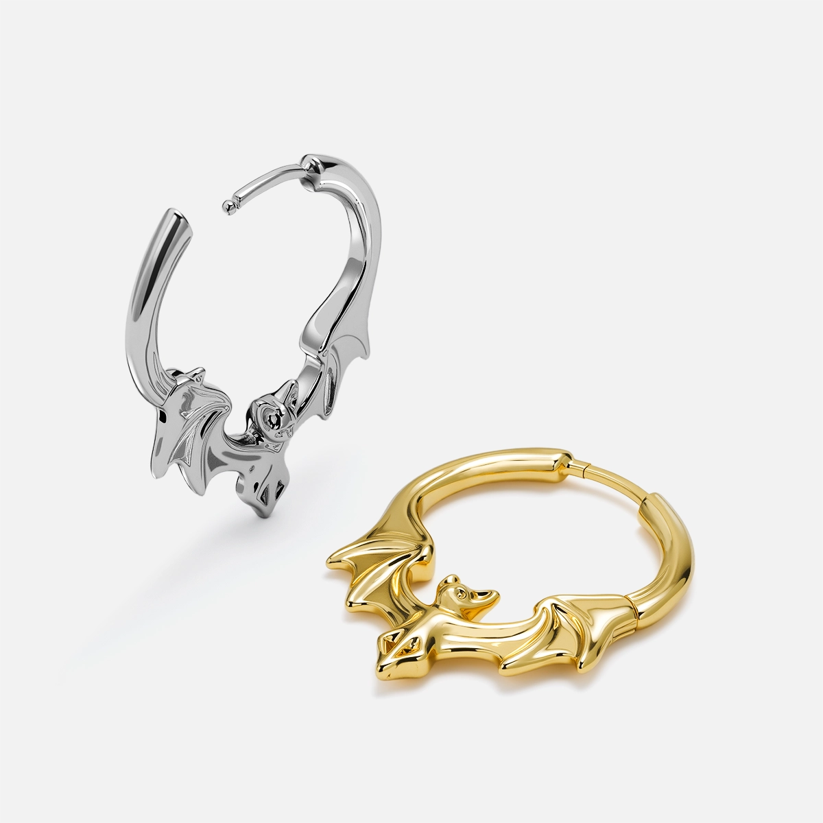 Two bat hoop earrings, one silver-tone and one gold-tone, shown side by side