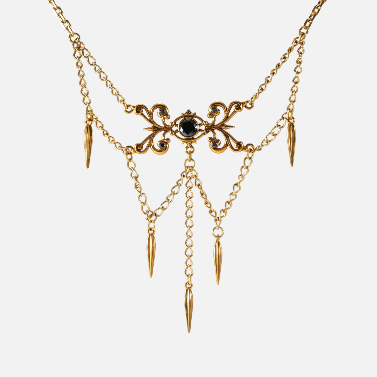 Gold-tone Gothic Cascade layered necklace with a black center stone and multiple spike drops