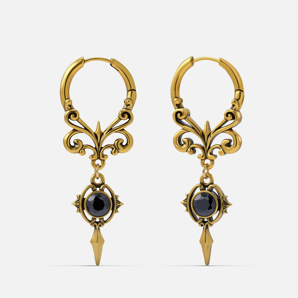 Pair of gold-tone Gothic Crest hoop earrings with scrolling filigree, black oval stones, and pointed drops