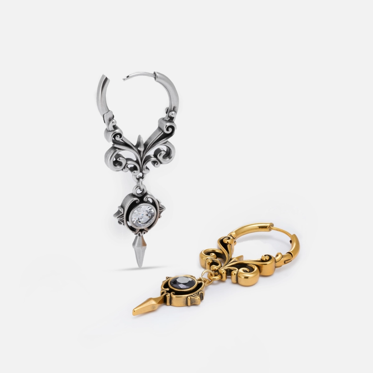 Silver and gold-tone Gothic Crest hoop earrings arranged upright and flat to show their ornate drops