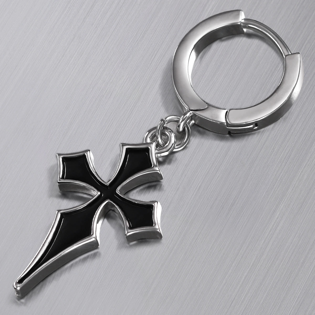 Close-up of silver Gothic Cross hoop earring with black cross pendant