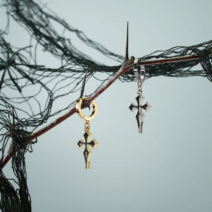 Pair of silver Gothic Cross hoop earrings displayed on a dark branch