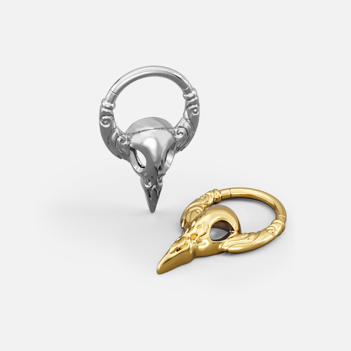 Silver- and gold-tone Gothic Raven Clickers shown from multiple angles to display the skull shape and ring profile.