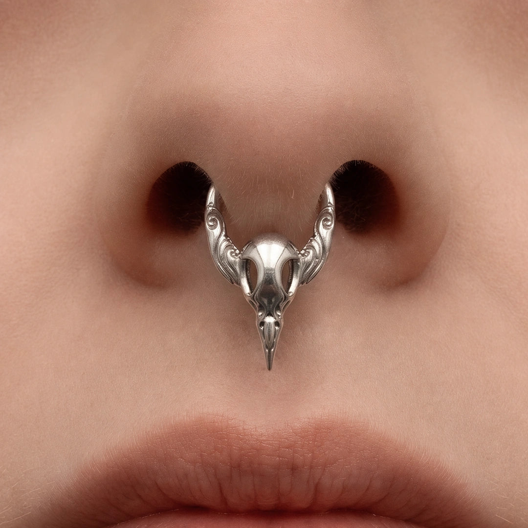 Silver-tone Gothic Raven Clicker worn as a septum ring, featuring a detailed raven skull design.