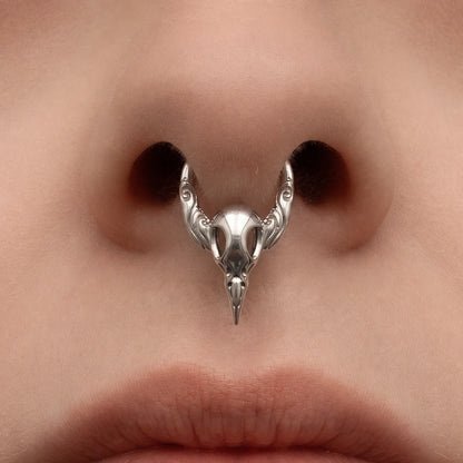 Silver-tone Gothic Raven Clicker worn as a septum ring, featuring a detailed raven skull design.