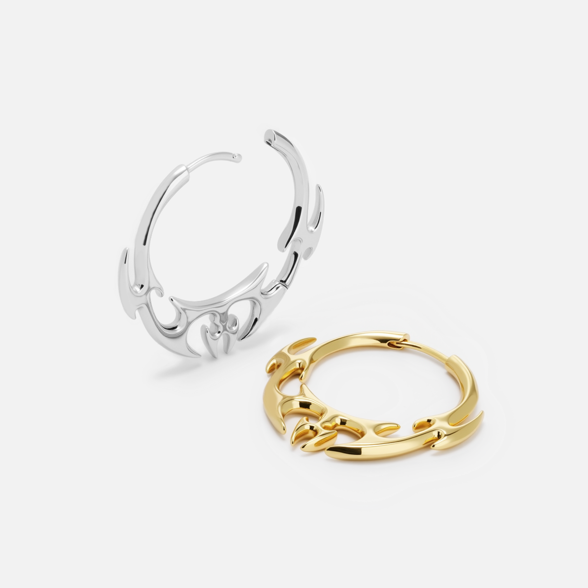 Silver and gold Hellfire Wing hoop earrings shown open and lying flat
