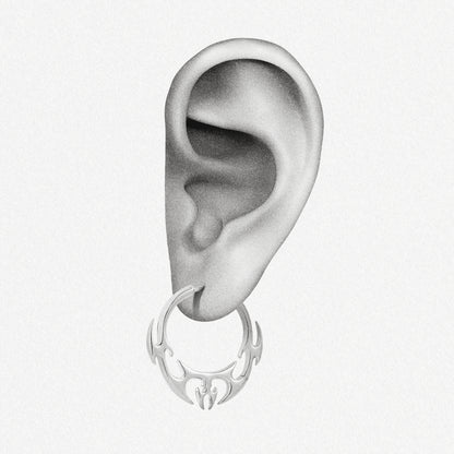 Illustration of an ear wearing a silver-tone hoop earring with a flame or wing motif at the base