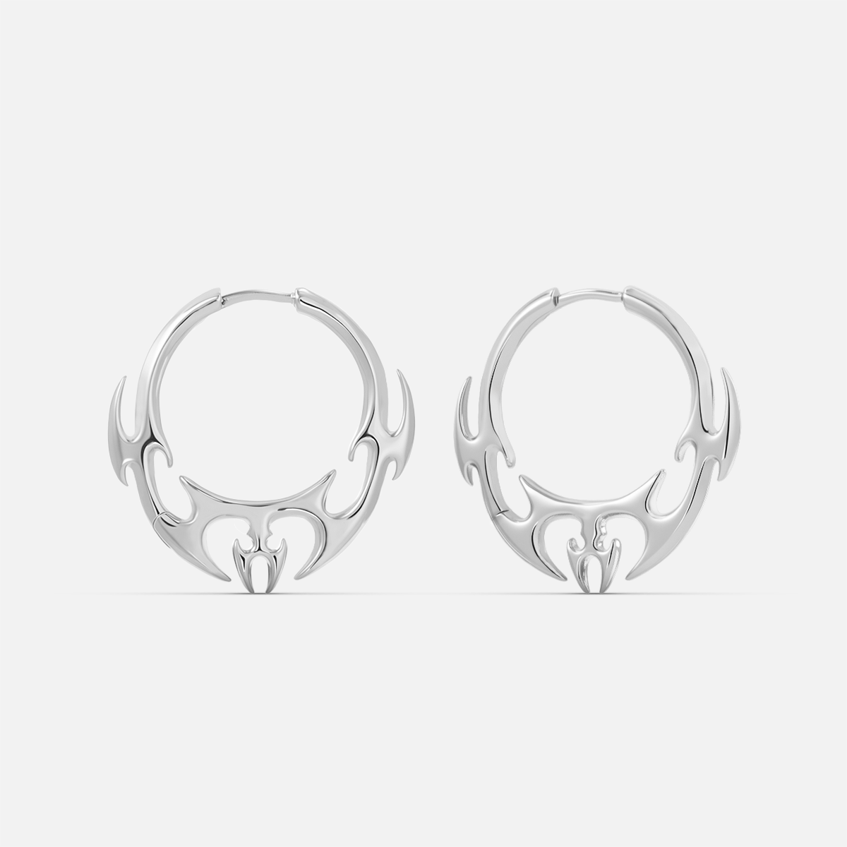 Silver-tone hoop earrings pair with flame-like wing motif hanging from the lower edge, front view
