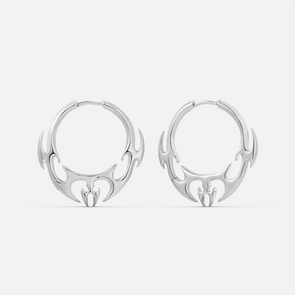 Silver-tone hoop earrings pair with flame-like wing motif hanging from the lower edge, front view