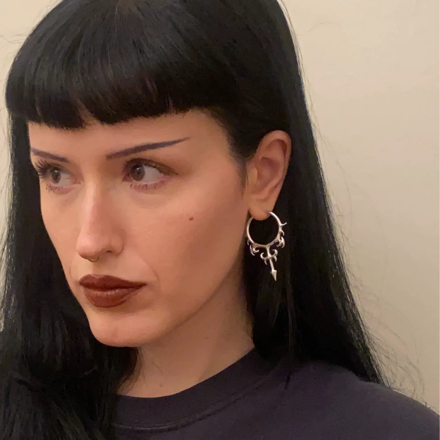 hellflame blade earrings shown on a model in front view, featuring silver hoop earrings with curved flame details and blade drops