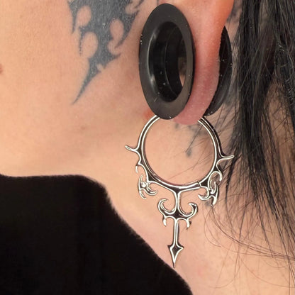 Model wearing the silver Hellflame Blade Earrings with flame-like curves, pointed blade drop, and bold gothic ear styling.