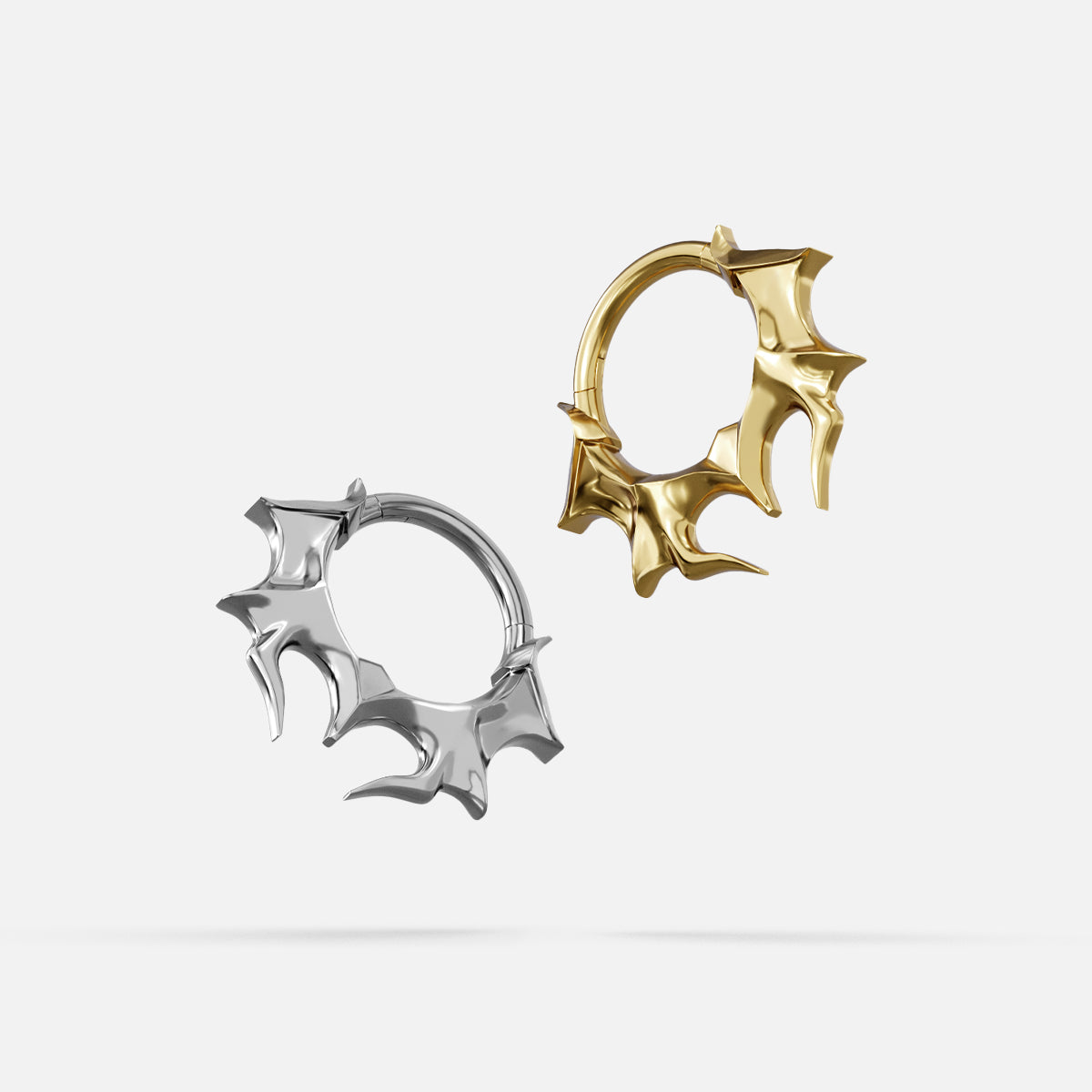 Silver- and gold-tone Infernal Horn Clickers displayed together to compare the two finishes.