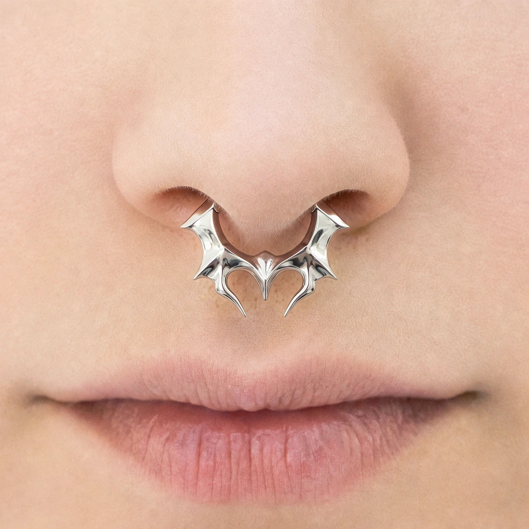 Silver-tone Infernal Horn Clicker worn as a septum ring, featuring a bold pointed horn design.