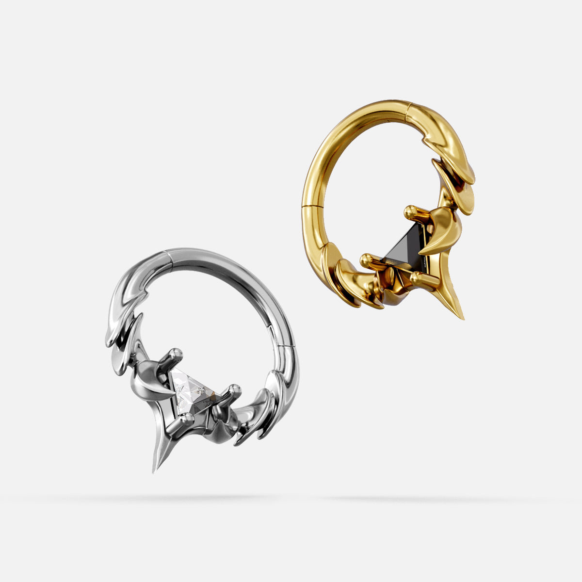 Two Keystone Ridge Clicker hoops shown side by side, silver-tone with clear gem and gold-tone with dark gem