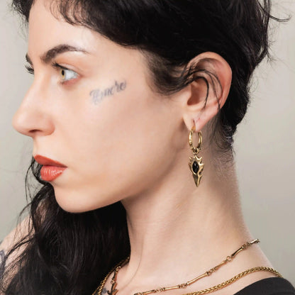 Gold Knapped Stone Earrings styled on model with dark stone inlay and gothic drop earring design