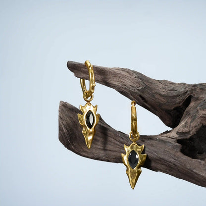 Gold Knapped Stone Earrings displayed on driftwood with black obsidian arrowhead drops