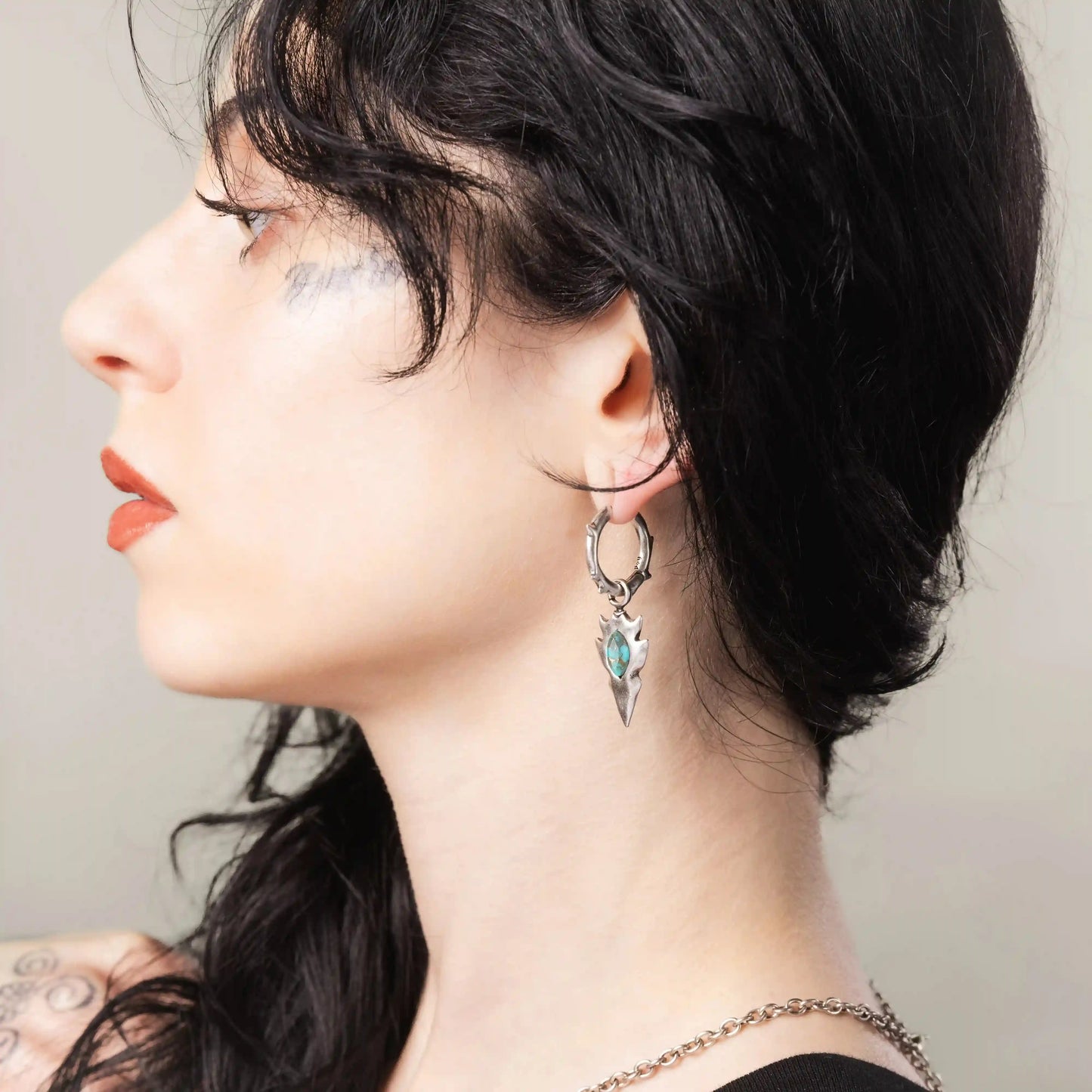 Silver Knapped Stone Earrings styled on model with turquoise stone drops and primal arrowhead silhouette