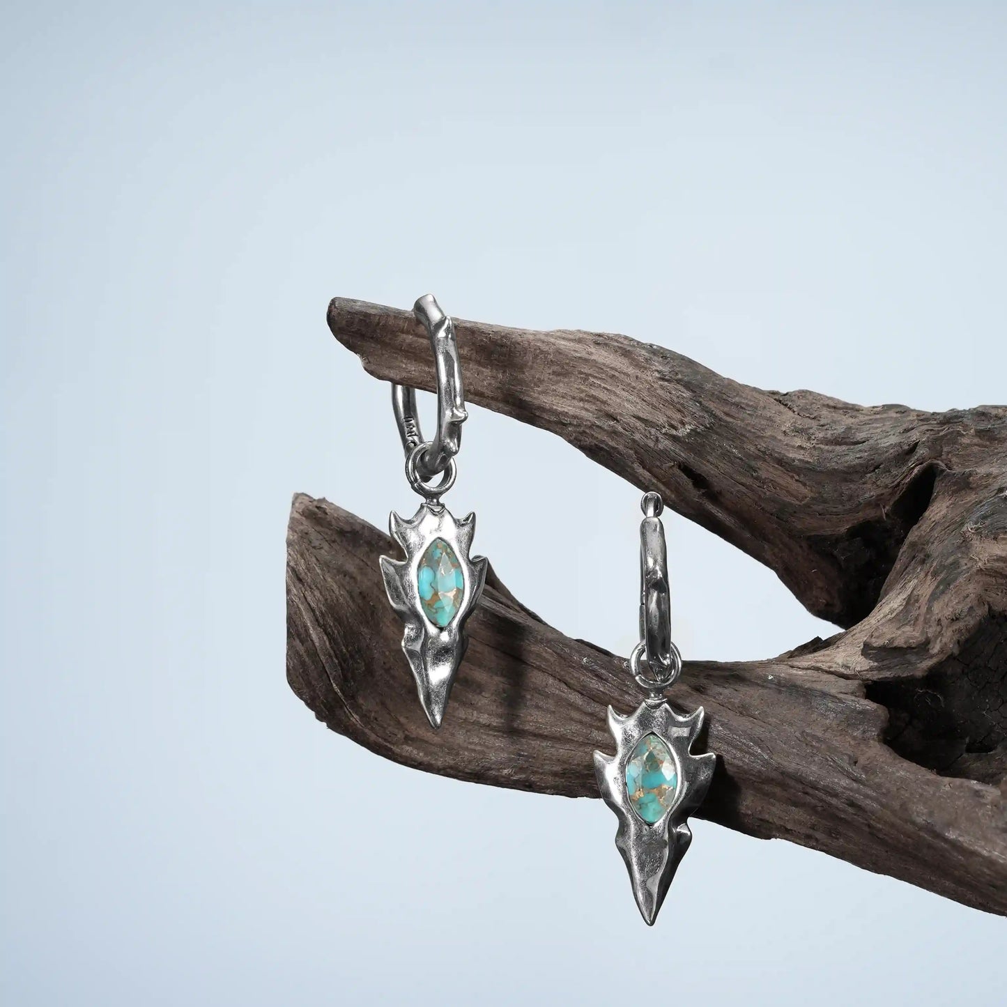 Silver Knapped Stone Earrings displayed on weathered wood with turquoise stone arrowhead drops