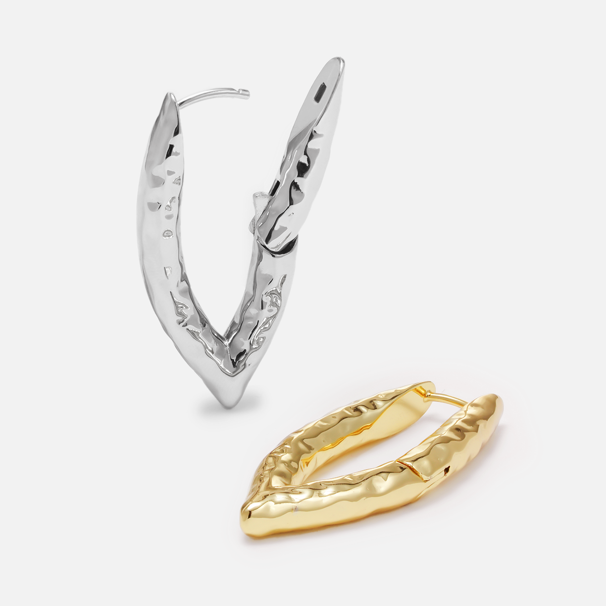 One silver-tone and one gold-tone liquid metal hoop earring laid side by side showing hammered texture