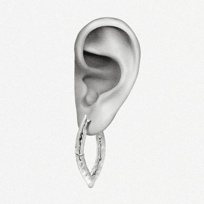 Silver-tone liquid metal hoop earring with hammered texture shown worn on an ear model