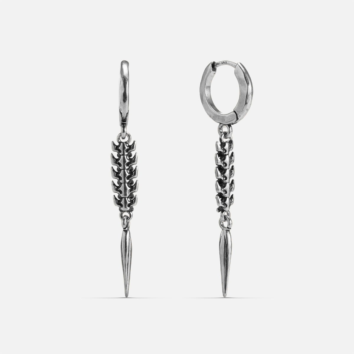 Silver-tone huggie hoop earrings with a spine-like segmented drop ending in a tapered spike