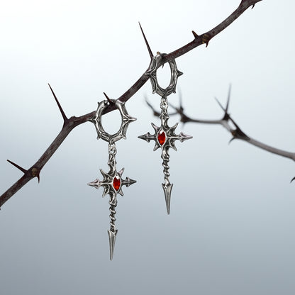 Pair of silver Longinus Blood Relic earrings with red center accents on thorns