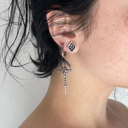 Model wearing silver Longinus Blood Relic Earrings with crimson core and long gothic spear drop design