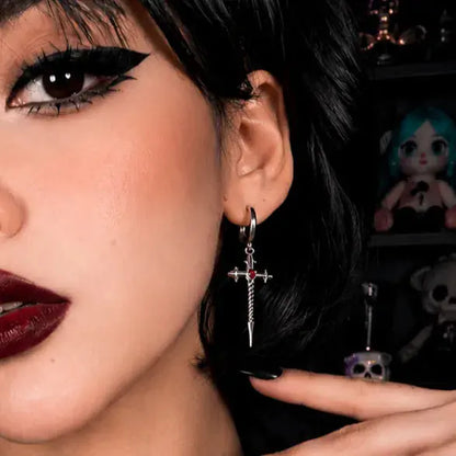 Longinus Godpiercer Earrings in 925 sterling silver, worn in a close black-haired portrait with bold red lipstick and a hand 