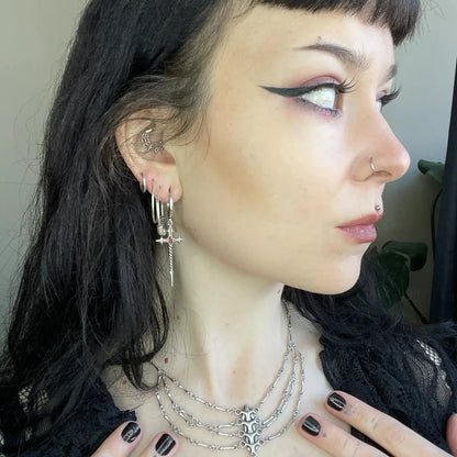 Longinus Godpiercer Earrings in 925 sterling silver, worn in a black-haired side profile with multiple ear piercings and laye