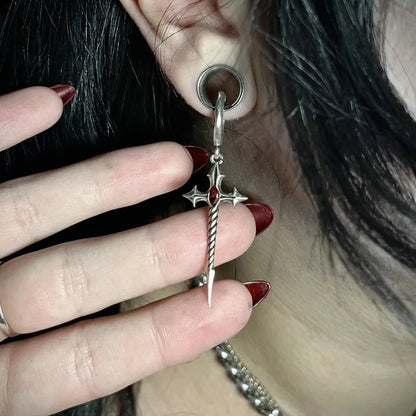 Longinus Godpiercer Earrings in 925 sterling silver, worn from a stretched lobe plug in a close-up with a hand framing the re